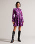 SAMMIEH-Dresses-Hello, gorgeous. SAMMIEH is the ultimate in flirty flower power. Featuring frills, cut outs and a vibrant floral print, this mini dress is just as at home with chunky boots as it is with sky high heels.The fabric of this product is made of 100% recycled polyester. Using recycled polyester helps divert plastic waste from ending in landfills and helps us to reduce our dependancy on virgin materials. Mini dress Floral print Fit and flare Long sleeved with frill cuffs High neck Zip fastening Tie